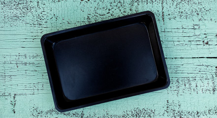 Old vintage baking pan and tins on wooden background.