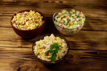 Set of festive mayonnaise salads on wooden table