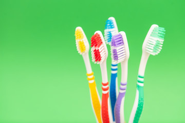 set of plastic toothbrushes on green background