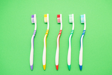 set of plastic toothbrushes on green background