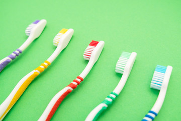 set of plastic toothbrushes on green background