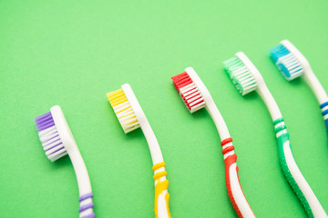 set of plastic toothbrushes on green background