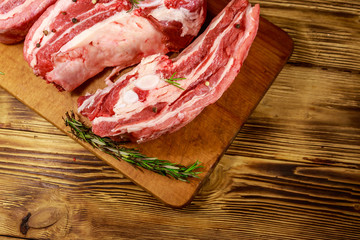 Raw pork ribs with spices and rosemary on wooden table. Top view