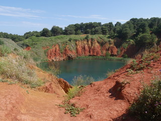 Fototapeta na wymiar Otranto Bauxite Pond is an abandoned mining quarry for the extraction of bauxite. The presence of a water table, encountered during the excavation phase, caused the formation of a small pond.