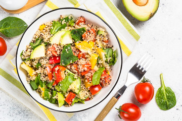 Quinoa salad with fresh vegetables on white.