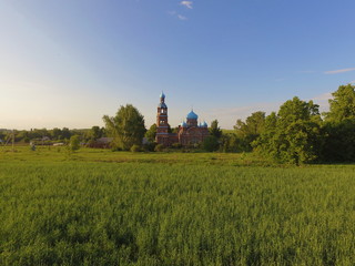 Green grass, blue sky, and a Church of our lady mother of Kazan in Smolyarova in the distance. Tatarstan, Russia
