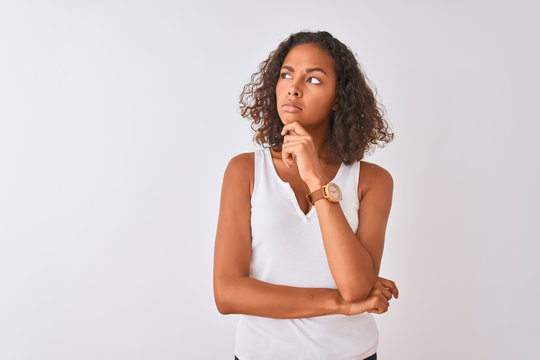 Young brazilian woman wearing casual t-shirt standing over isolated white background Thinking worried about a question, concerned and nervous with hand on chin
