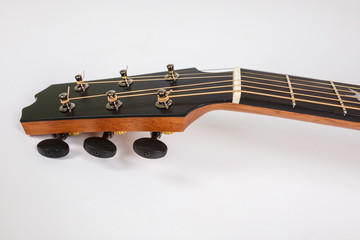 Tuning pegs on wooden machine head of six strings guitar on white background