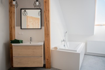 loft bathroom with mirror and bathtub. White walls