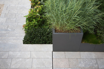 Moderne Garten- und Terrassengestaltung im Materialmix: Terrasse aus Steinplatten umgeben von...