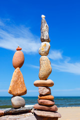 Two Rock zen pyramids of colorful pebbles on a beach on the background of the sea. Concept of...
