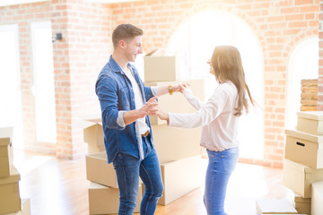 Obraz premium Beautiful young couple having fun dancing at new apartment, celebrating moving to a new home
