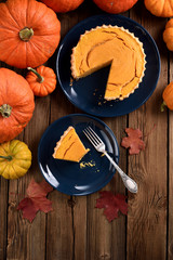 Autumn still life. Traditional pumpkin pie with bright pumpkins on wooden background rustic style copy space