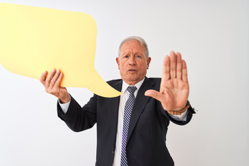 Senior grey-haired businessman holding speech bubble over isolated white background with open hand doing stop sign with serious and confident expression, defense gesture