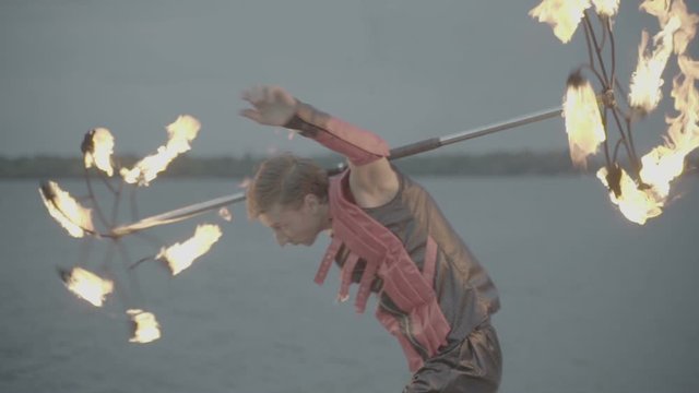 Man with torch fire show on the river bank at sunset. slow motion S-Log3, S-Gamut3, Cine