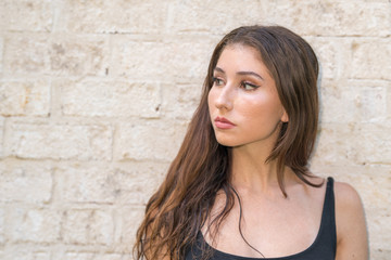 Portrait headshot of a beautiful young woman glancing away from camera