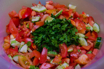multi-layered vegetable salad with hazelnuts on a blue dish on a blue tablecloth with a pattern