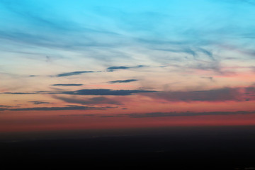 Air view of the sky and horizont from above. From Blue, yellow and red to black. The sunset look like a pattern of marble. Nice backdrop / background.