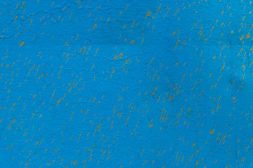 old rusty metal surface painted with peeling and cracked blue paint from time to time as an abstract background with large cracks