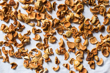 dried fruits apples and pears yellow-brown lie on a white cloth