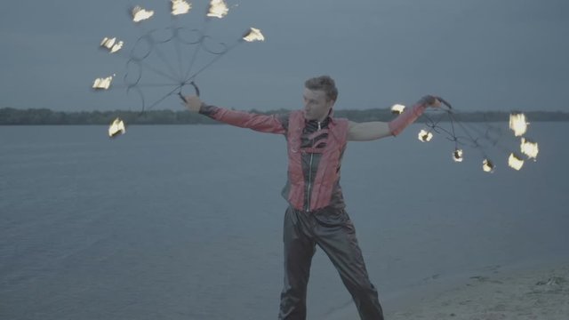 Man with torch fire show on the river bank at sunset. slow motion S-Log3, S-Gamut3, Cine