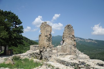 Fototapeta na wymiar The ruins of the ancient walls of the Georgian fortress Ujarma against the backdrop of the Caucasus Mountains