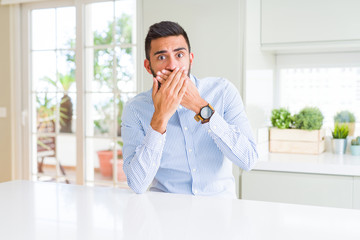 Handsome hispanic business man shocked covering mouth with hands for mistake. Secret concept.