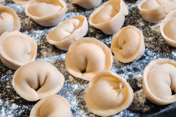 Raw dumplings on table sprinkled with flour