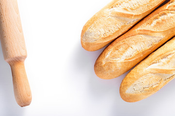 Freshly baked French baguettes on white wooden table.