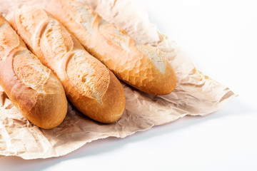 Freshly baked French baguettes on white wooden table.