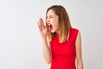 Redhead businesswoman wearing elegant red dress standing over isolated white background shouting and screaming loud to side with hand on mouth. Communication concept.