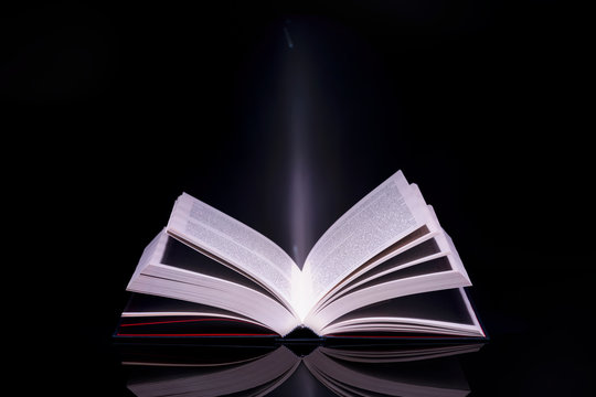 Book with glowing light coming from inside of it. High resolution image.