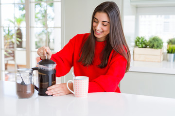 Young beautiful woman making morning coffee smiling, preparing a cup of latte for breakfast