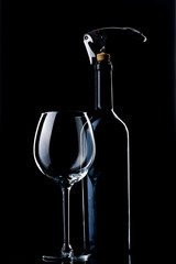 A bottle of wine. Wine glass. Natural cork. Metal corkscrew.