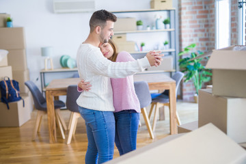 Young beautiful couple in love celebrating dancing moving to a new home, smiling very happy for new apartment