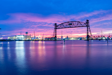 Vertical lift bridge for railroad over the Elizabeth River on the border of Norfolk and Chesapeake Virginia against a beautiful red, purple, pink, and blue sunset