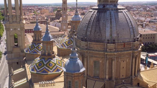 Aerial tilt shot view of dome and roof of famous landmark Basilica Our Lady of the Pillar. Zaragoza, Spain .