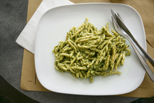 Troffie al pesto, pasta speciality of the Ligurian cuisine with sauce from garlic, pine nuts, basil and parmesan cheese, high angle view from above