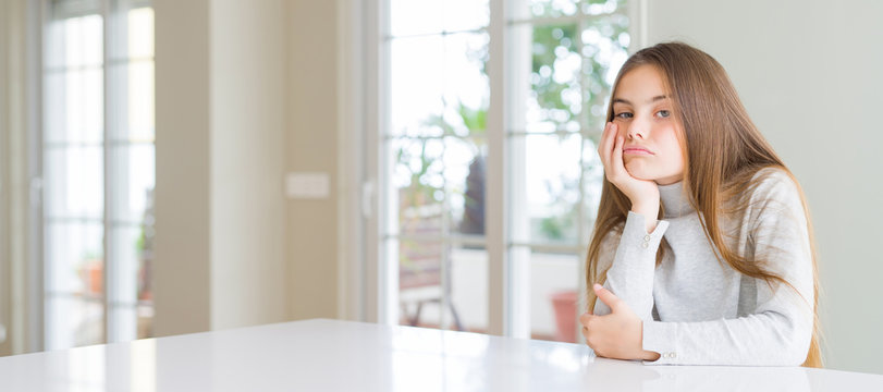 Wide angle picture of beautiful young girl kid wearing casual sweater thinking looking tired and bored with depression problems with crossed arms.