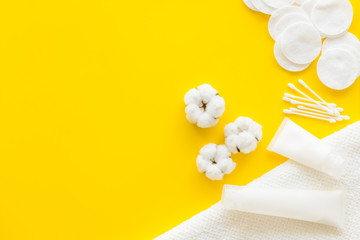 Hygiene cotton swabs, pads and cream for pattern on yellow background top view mockup