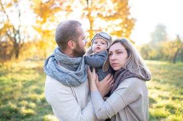 Happy family couple with child sincere emotions outdoor portrait.