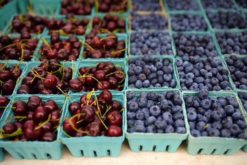 Fresh assorted berries at farmers market. Cherries and blueberries