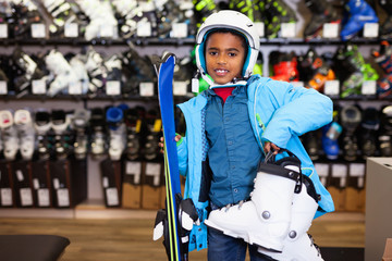 Happy African American tweenager in skiing outfit in modern store of sports equipment