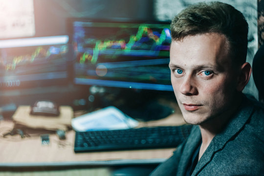 Young male businessman at a computer monitors the schedule of exchange rates on the online cryptocurrency exchange