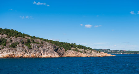 Fototapeta na wymiar Beautiful seascape norwegian coastline, coast of Kristiansand with small lighthouse, Scandinavia, Norway. July 2019