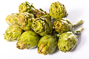 Obraz premium Uncooked green artichokes on a white surface
