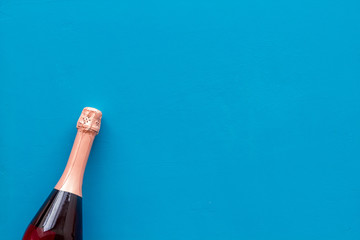 Champagne bottle for celebration on blue background top view mock up