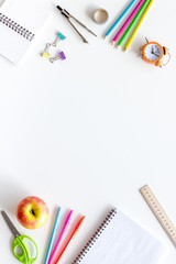 Student accessories frame on pupil's desk white background top view mockup