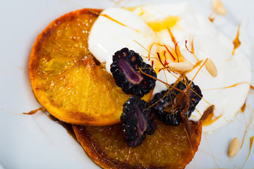 Dessert of caramelized oranges, blackberries and yogurt
