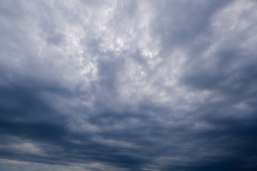 Obraz premium Beautiful dramatic stormy sky and cloud before sunset with god light. Deep blue light beam with sun rays between cumulonimbus cloudscape. 